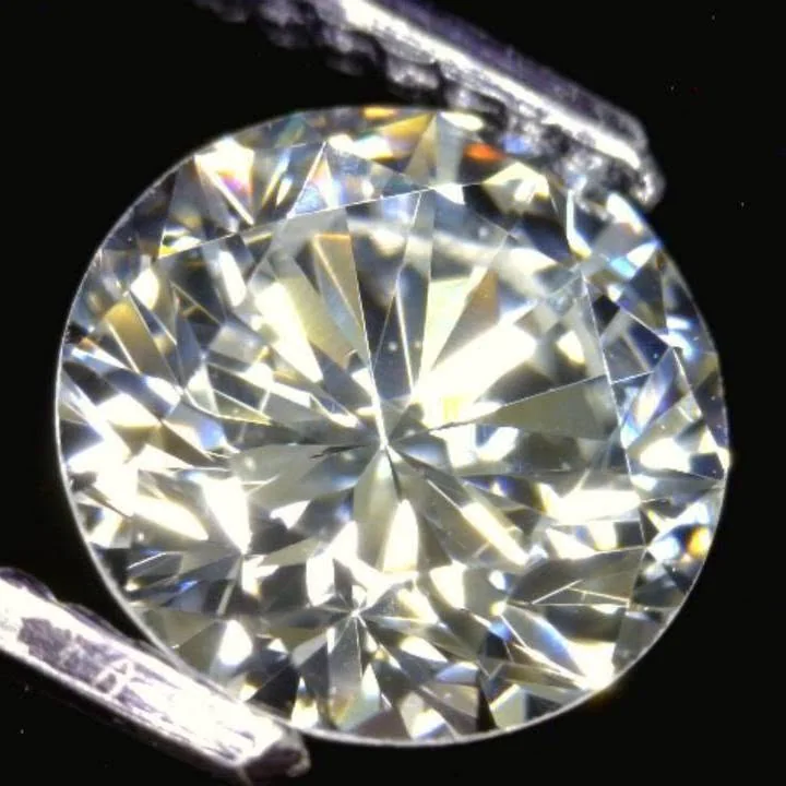 A round brilliant diamond held in tweezers